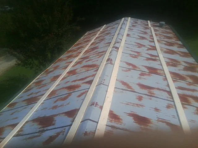 Rusted metal roof panels with new wood purlins before replacement — Storm Damage Roof Repair in Green Isle by Roofing Brothers