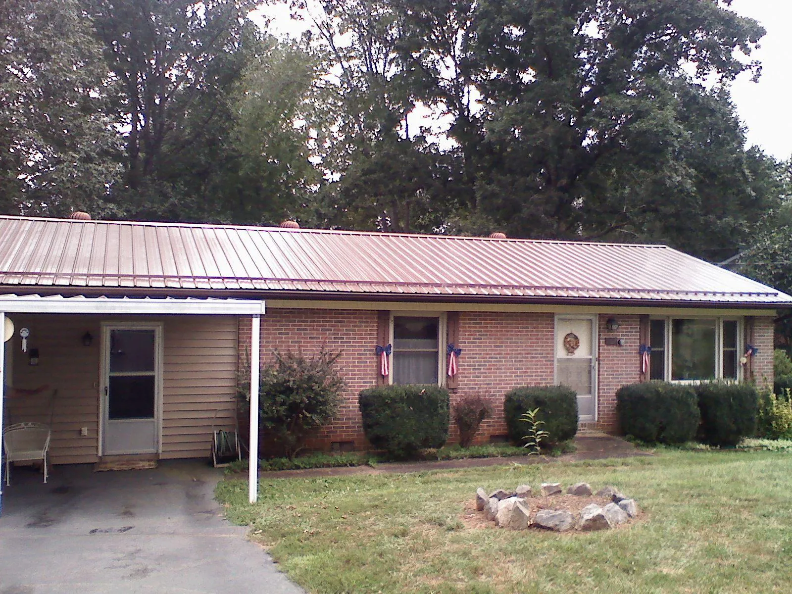 Bronze metal roof and carport on a brick ranch home — Roof Repair work by our crew in Green Isle