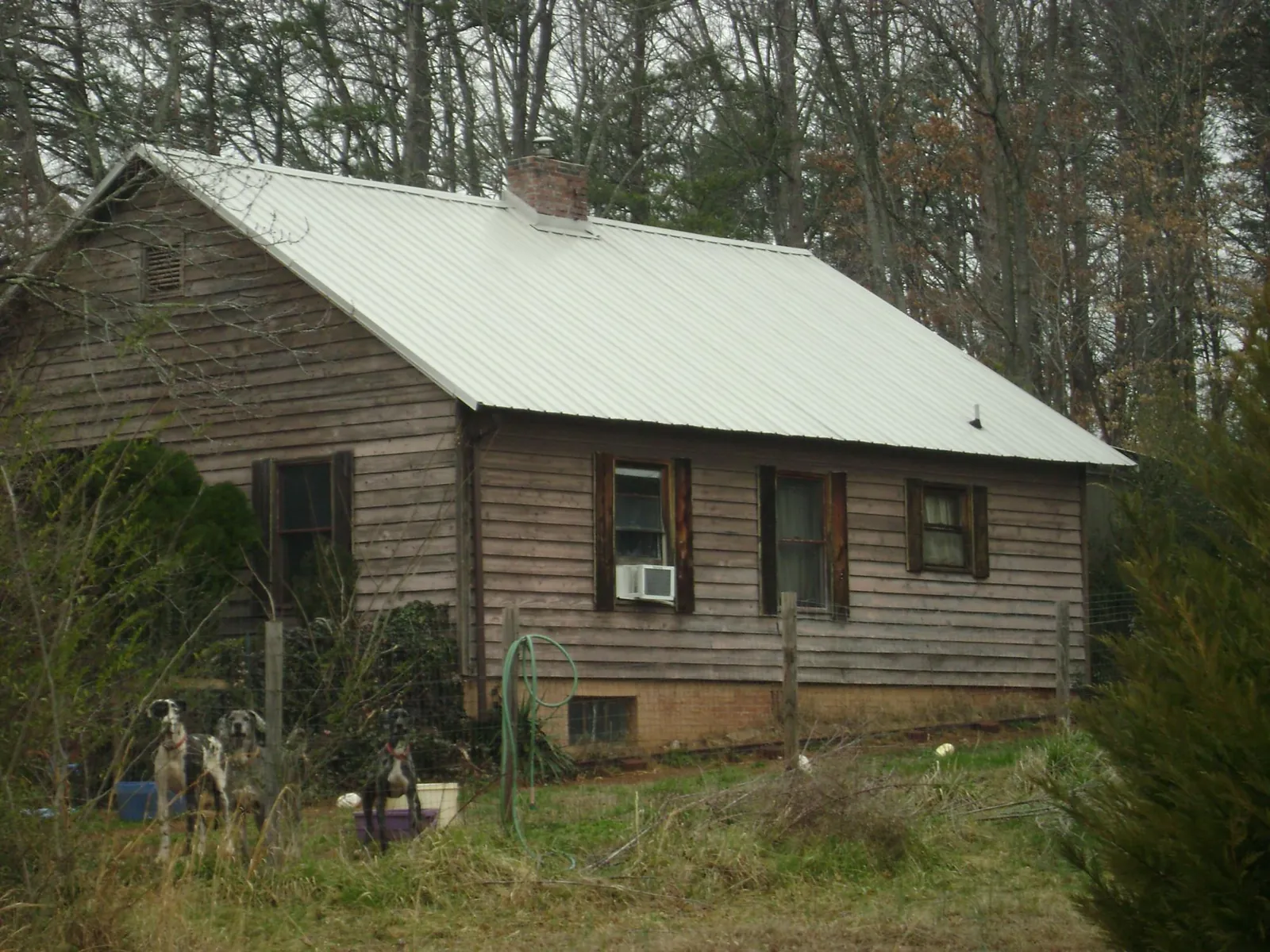 White metal roof on an old wood sided farmhouse, from a Metal Roof Installation job in Green Isle